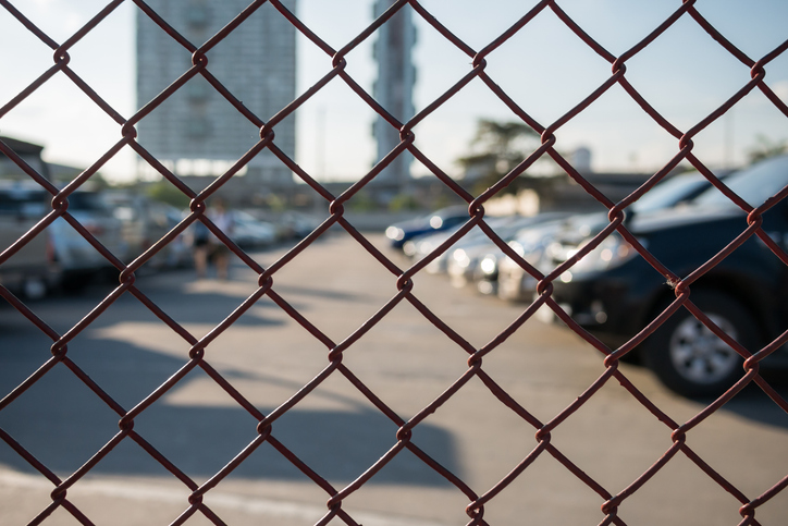 a man standing next to a fence