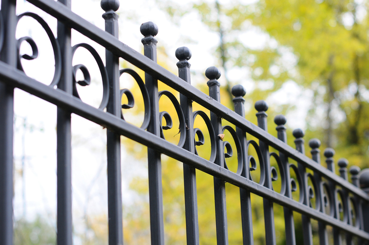 a close up of a street sign in front of a fence